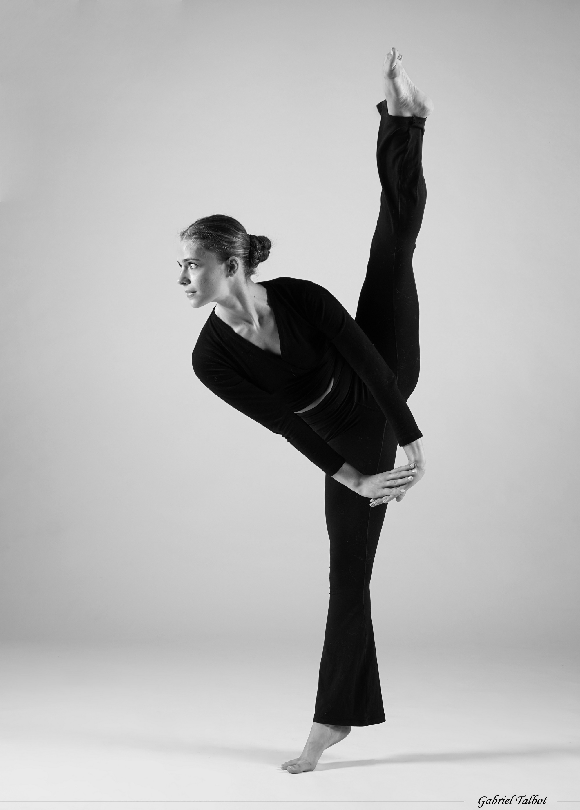Illenia Vargas en équilibre, une jambe tendue vers le haut, photographiée en noir et blanc.